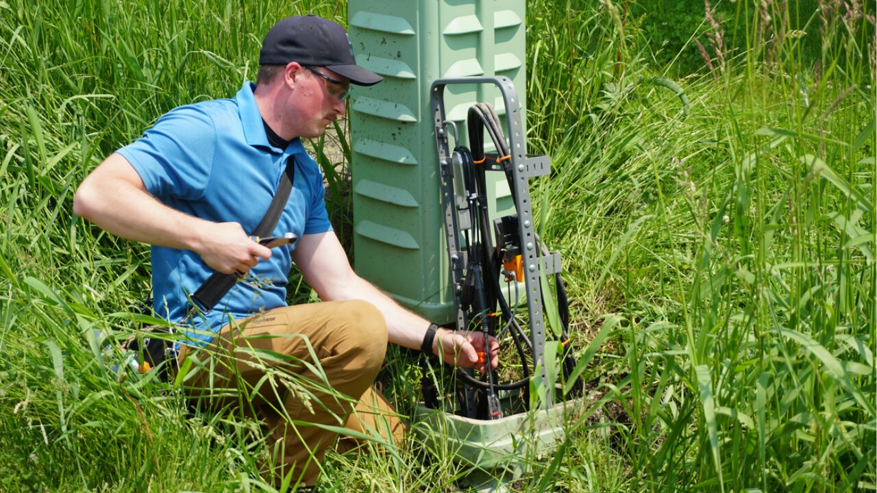Technician wearing safety glasses while working in a fiber cabinet.