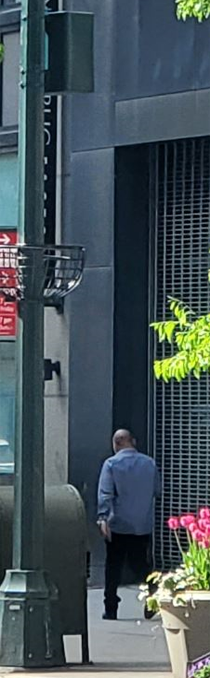 Image of a man walking next to a large building