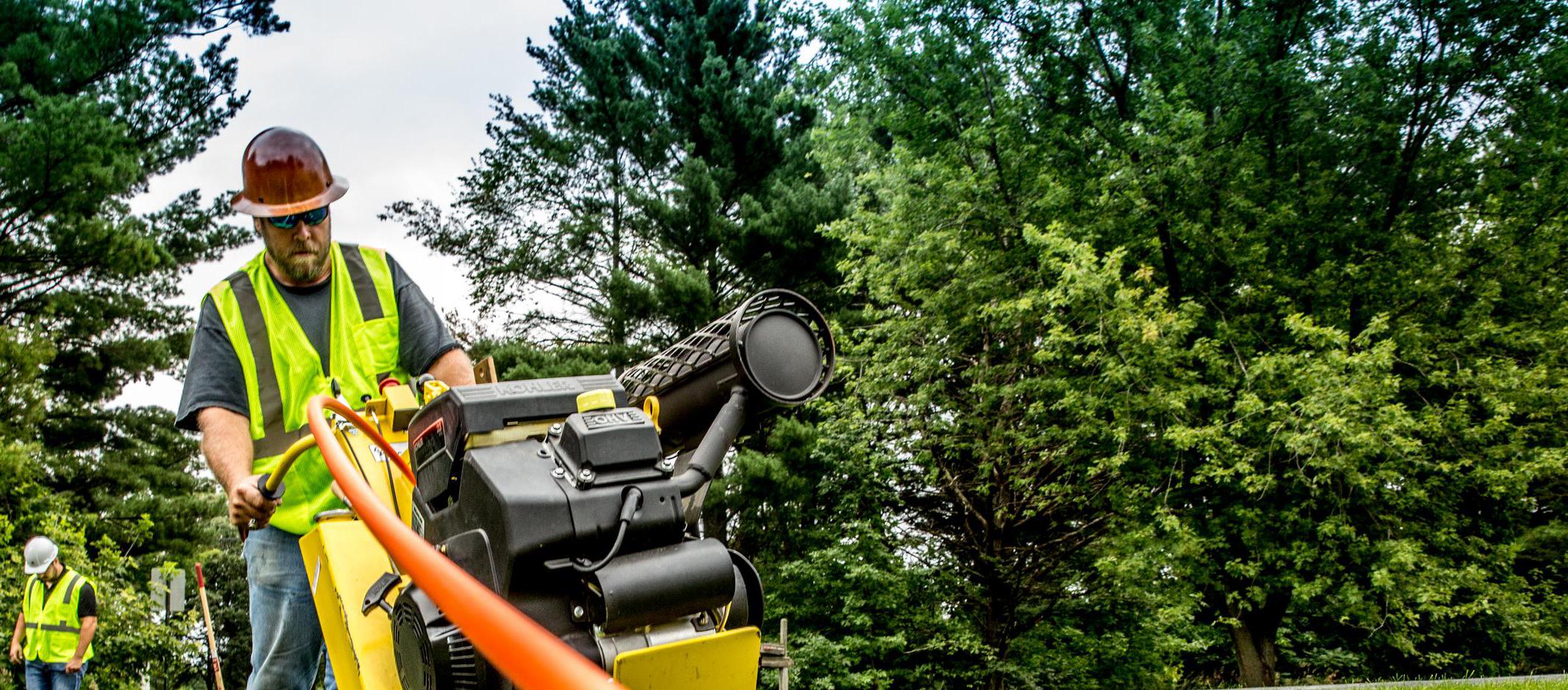 Worker operating a cable laying machine.